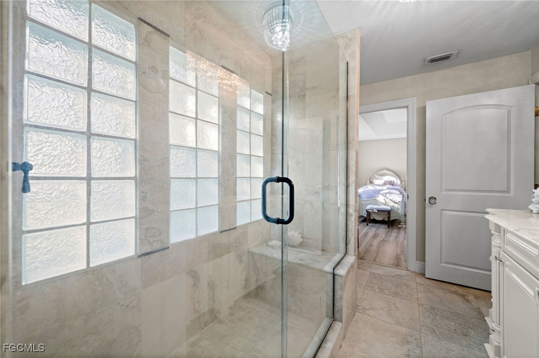 9250 The Lane Naples, FL 34109 - Photo 42 of 50 a bathroom with a granite countertop shower a mirror and a shower