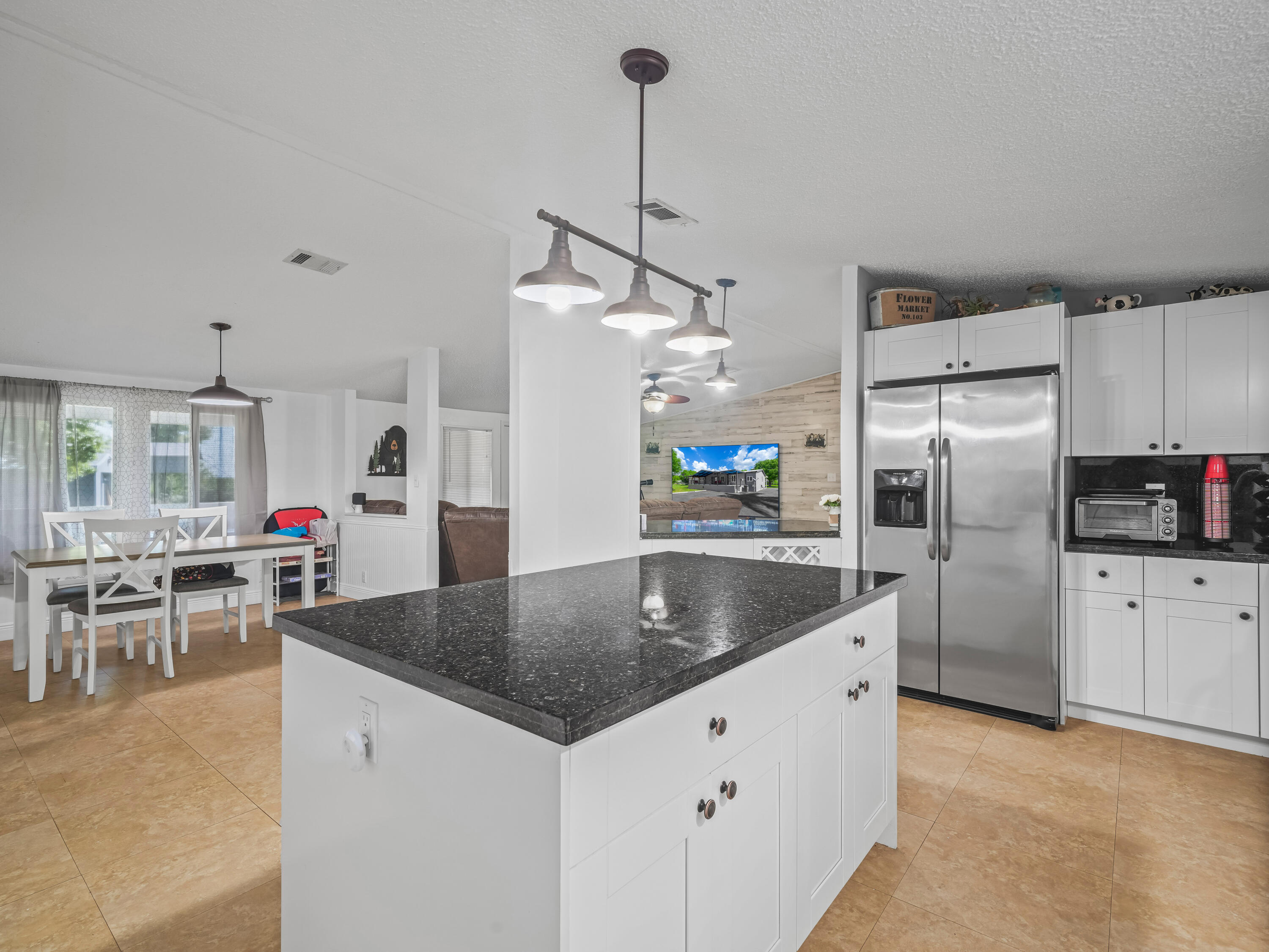 329 Kilpatrick Loop Clewiston, FL 33440 - Photo 10 of 56 a kitchen with stainless steel appliances granite countertop a refrigerator a sink a stove and chairs