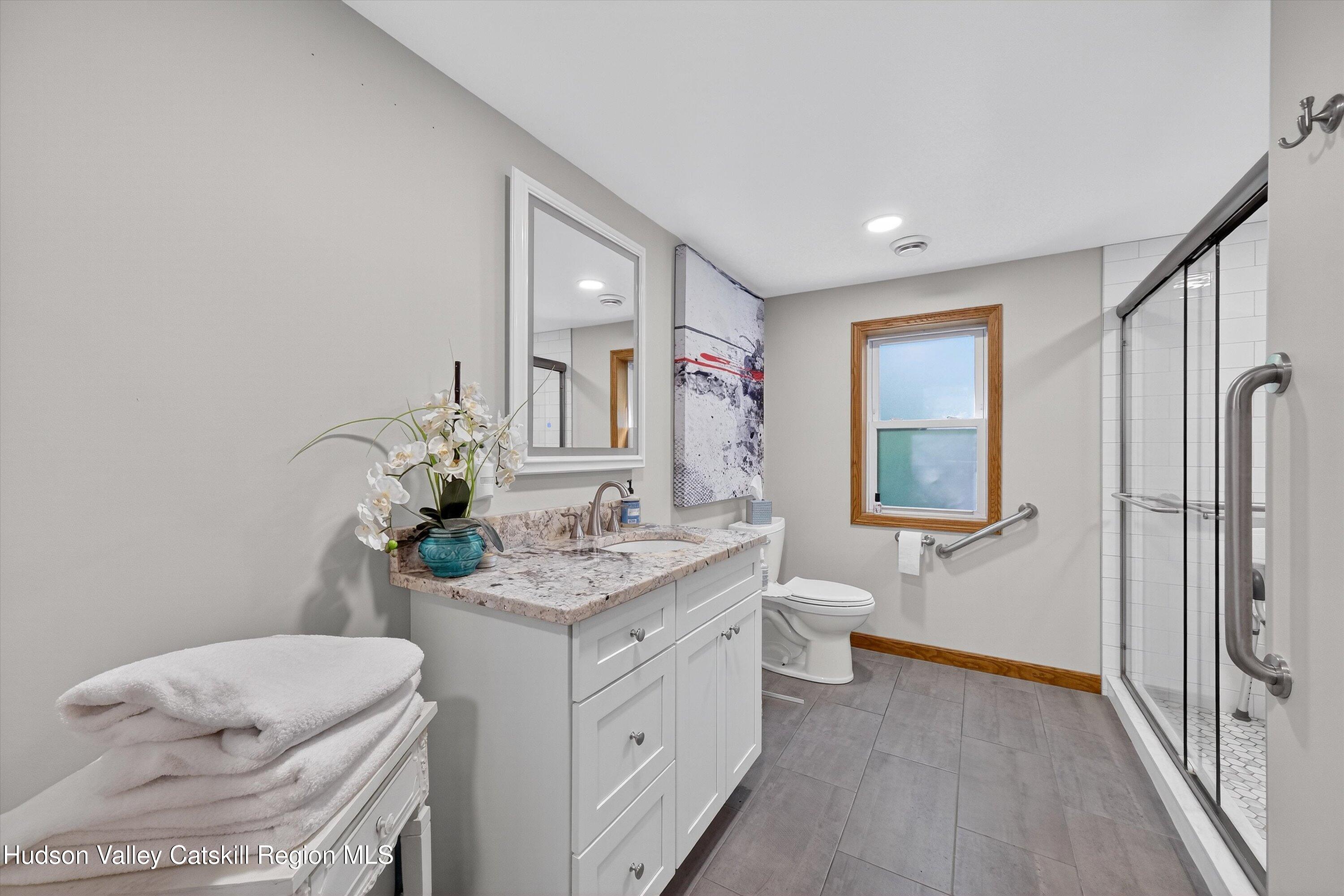 6 Hasbrouck Place New Paltz, NY 12561 - Photo 15 of 38 a bathroom with a sink a toilet and mirror