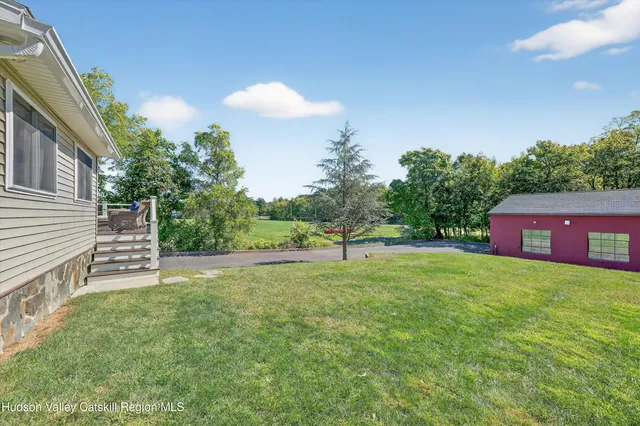 a view of an house with backyard and a tree