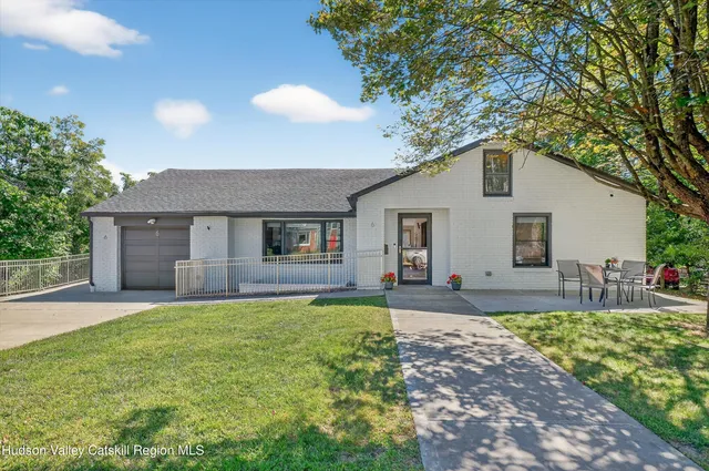 a front view of house with yard and trees around