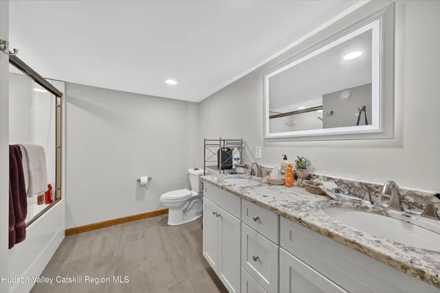 a bathroom with a granite countertop sink toilet and shower