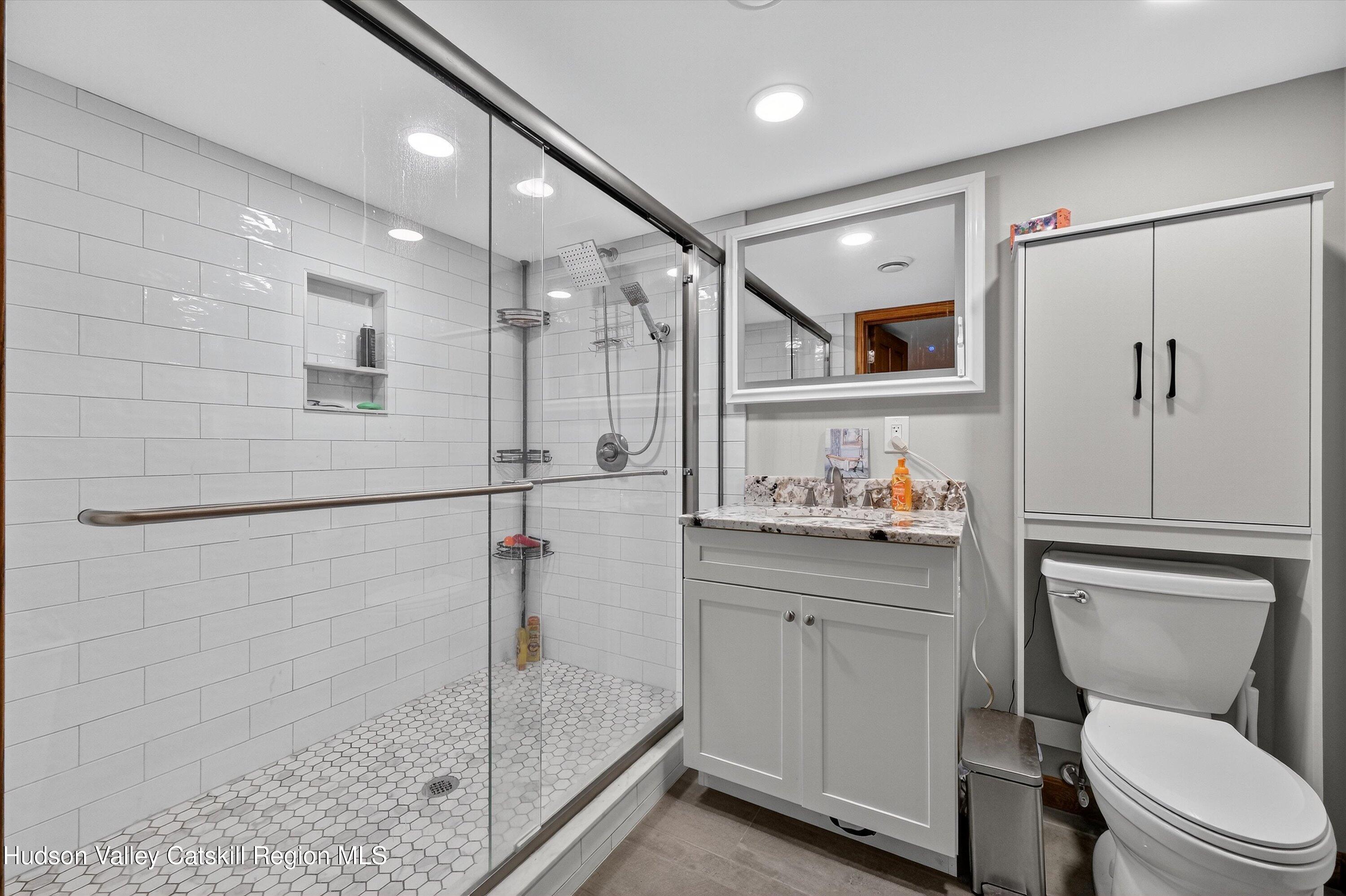 6 Hasbrouck Place New Paltz, NY 12561 - Photo 30 of 38 a bathroom with a shower sink vanity mirror and toilet