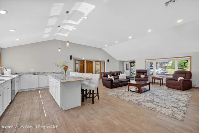 a large living room with stainless steel appliances granite countertop furniture a couch and a view of living room