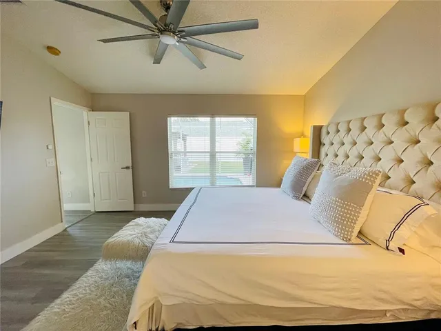 a bedroom with a large bed and ceiling fan