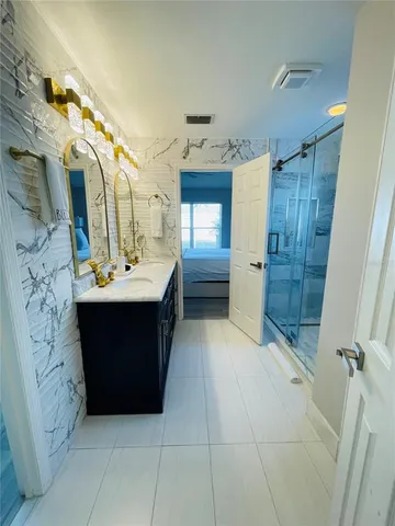 a bathroom with a sink vanity and tub
