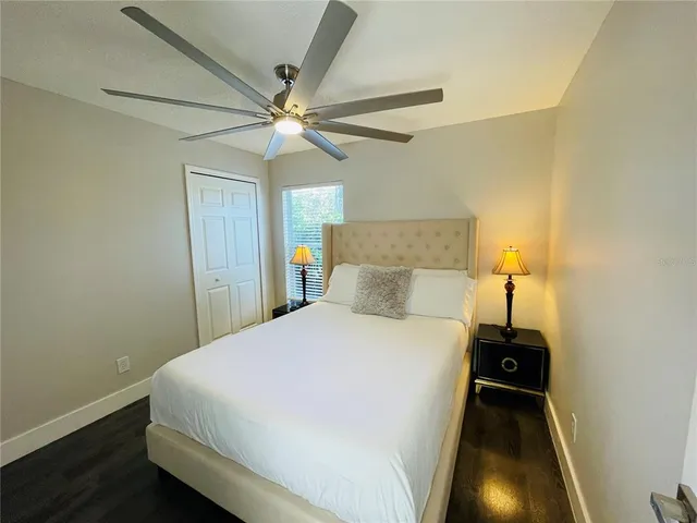 a bedroom with a bed and a ceiling fan