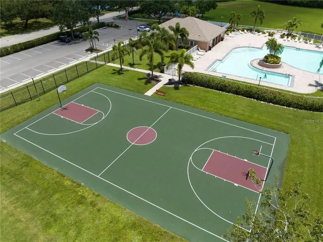 a view of a tennis ground with large trees