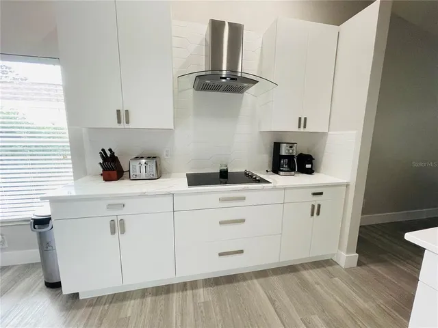 a kitchen with white cabinets and sink