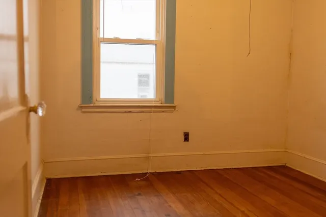 a view of a small space with wooden floor and a window
