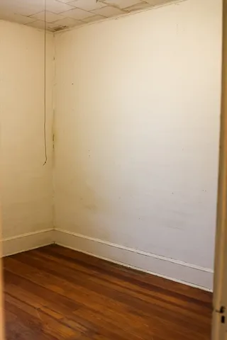 a view of a small space with wooden floor and a window