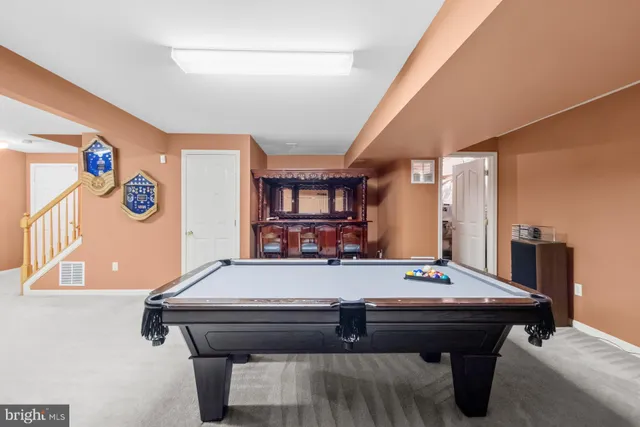 a room with pool table and windows