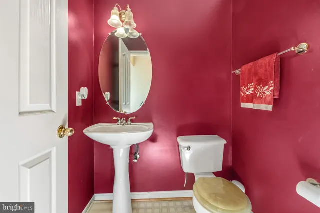 a bathroom with a toilet a sink and mirror