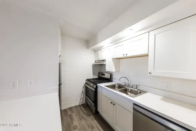 a kitchen with stainless steel appliances a white stove top oven sink and cabinets