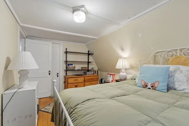 a bedroom with a bed and a lamp on the dresser