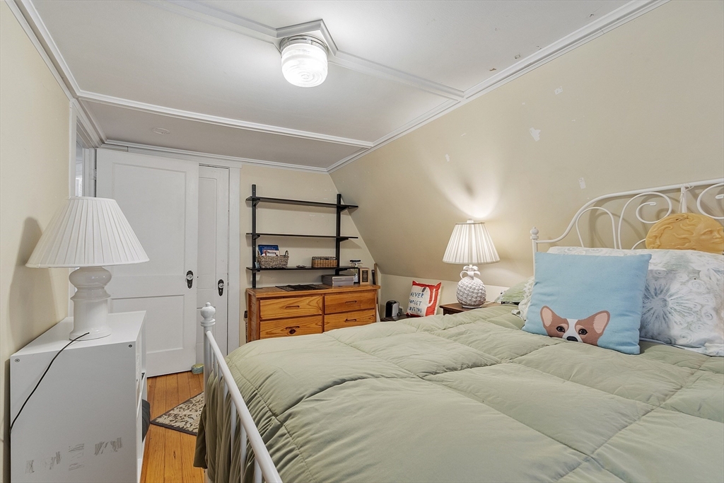 10 Oak Street, Unit 3 Gloucester, MA 01930 - Photo 19 of 24 a bedroom with a bed and a lamp on the dresser