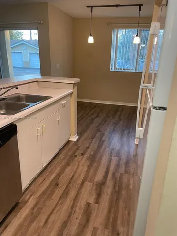 a utility room with wooden floor washer and dryer