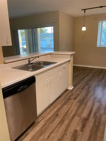a kitchen with a sink cabinets and wooden floor