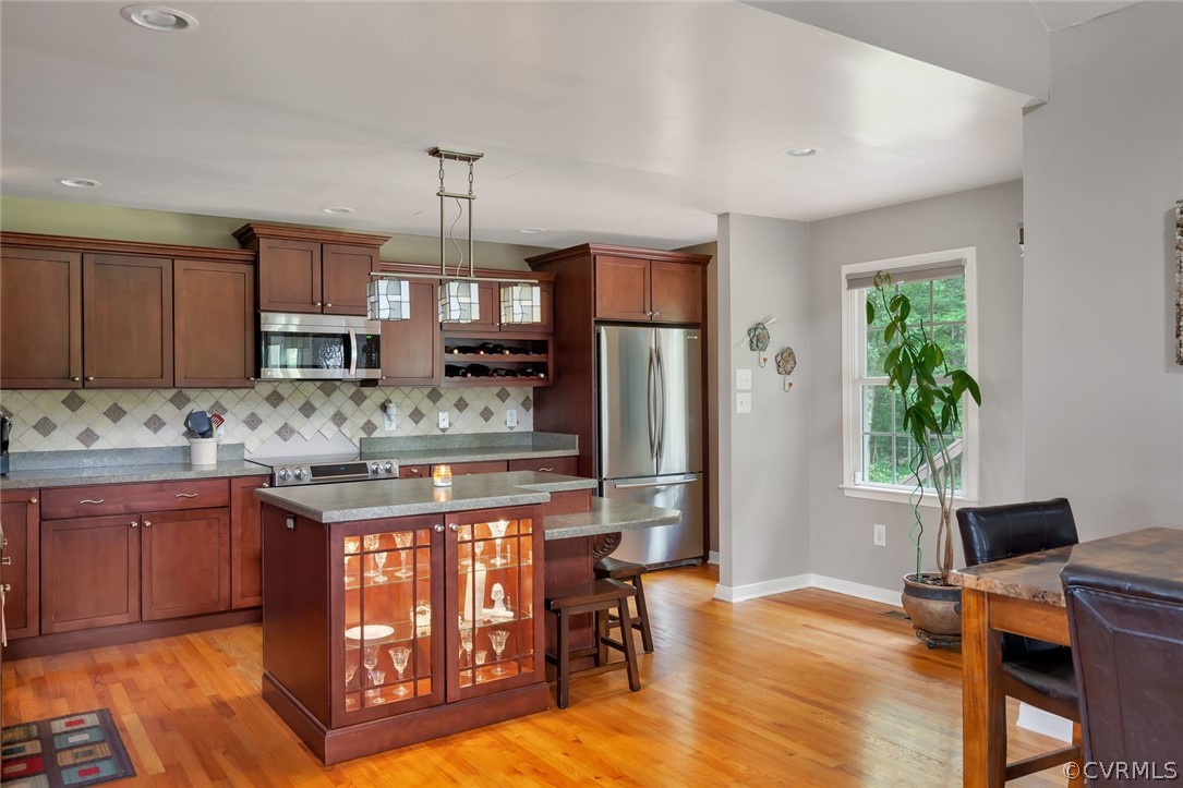 14498 Scotts Lane Carson, VA 23830 - Photo 13 of 44 a kitchen with stainless steel appliances granite countertop a refrigerator a sink dishwasher a stove and a dining table with wooden floor
