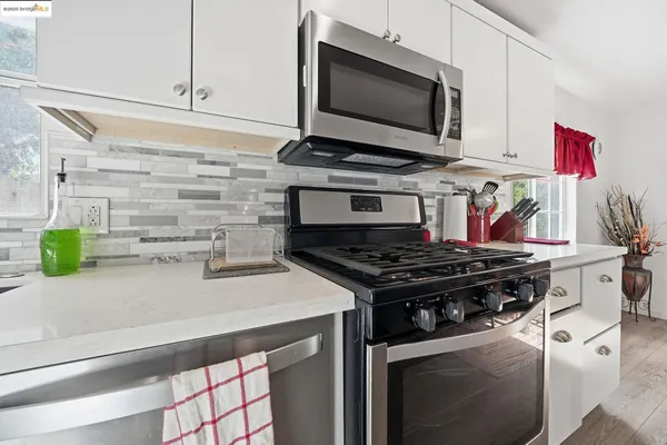 a kitchen with stainless steel appliances a sink stove and microwave