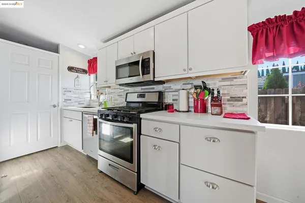 a kitchen with stainless steel appliances granite countertop a sink dishwasher and a refrigerator with wooden cabinets