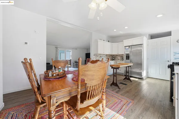 a dining room filled chandelier and wooden floor