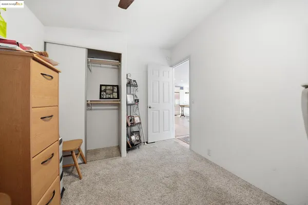 a bedroom with a bed and a flat tv screen on dresser