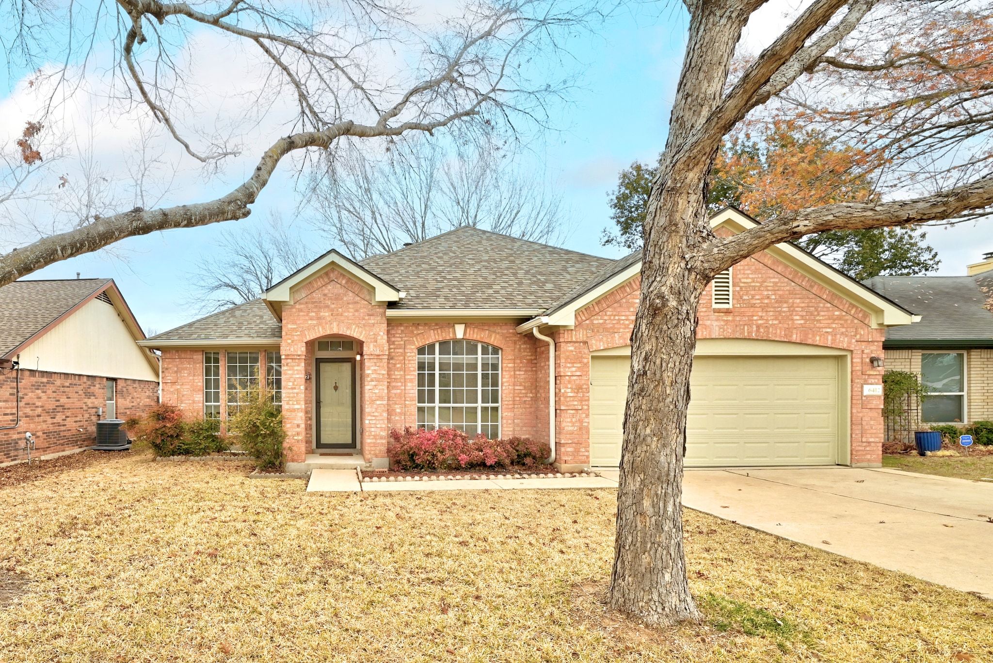 6412 Sailing Breeze Trail Austin, TX 78744 - Photo 2 of 18 a front view of a house with a yard and garage