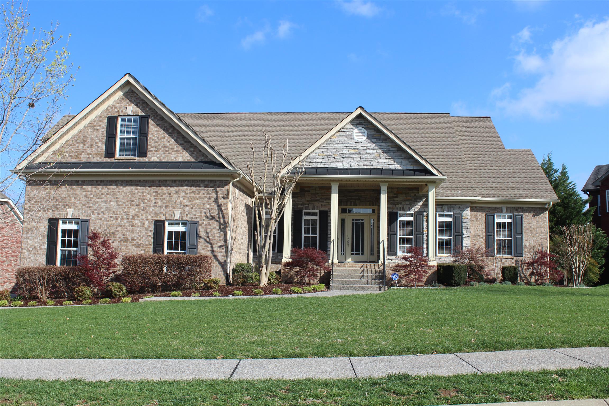 a front view of a house with a garden and plants