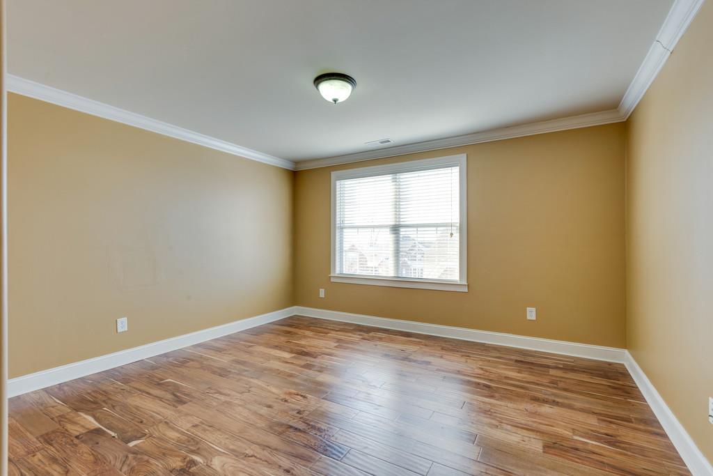1206 White Rock Road Spring Hill, TN 37174 - Photo 17 of 30 a view of an empty room with wooden floor and a window