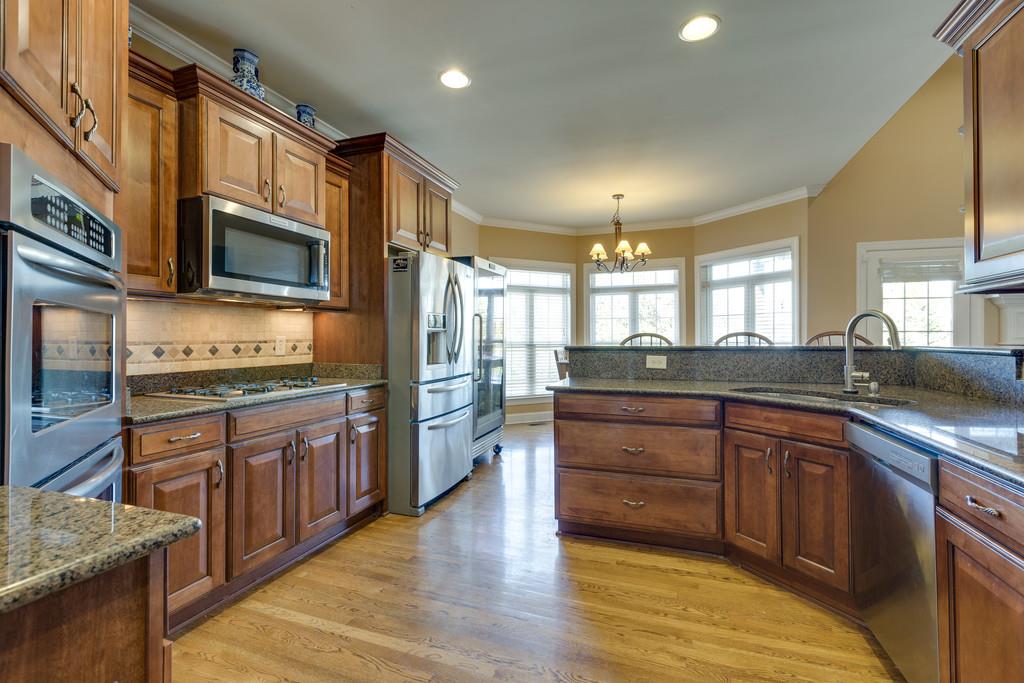 1206 White Rock Road Spring Hill, TN 37174 - Photo 10 of 30 a kitchen with stainless steel appliances granite countertop wooden cabinets a sink a stove a dining table and chairs