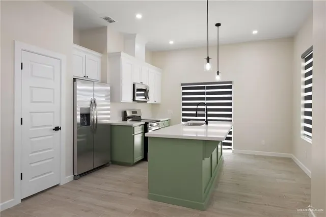 a kitchen with stainless steel appliances granite countertop a stove a sink and a refrigerator