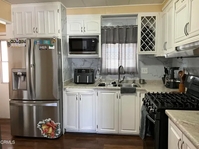 a kitchen with stainless steel appliances a refrigerator a sink and cabinets