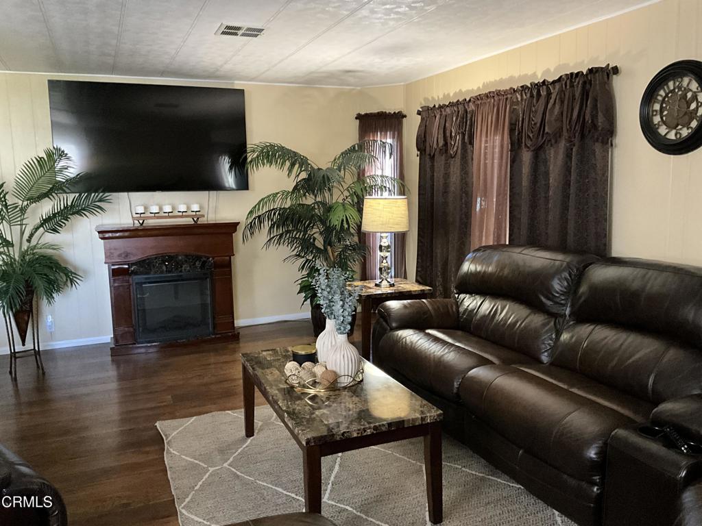 15433 West Telegraph Road, Unit 54 Santa Paula, CA 93060 - Photo 5 of 25 a living room with furniture a fireplace and a flat screen tv