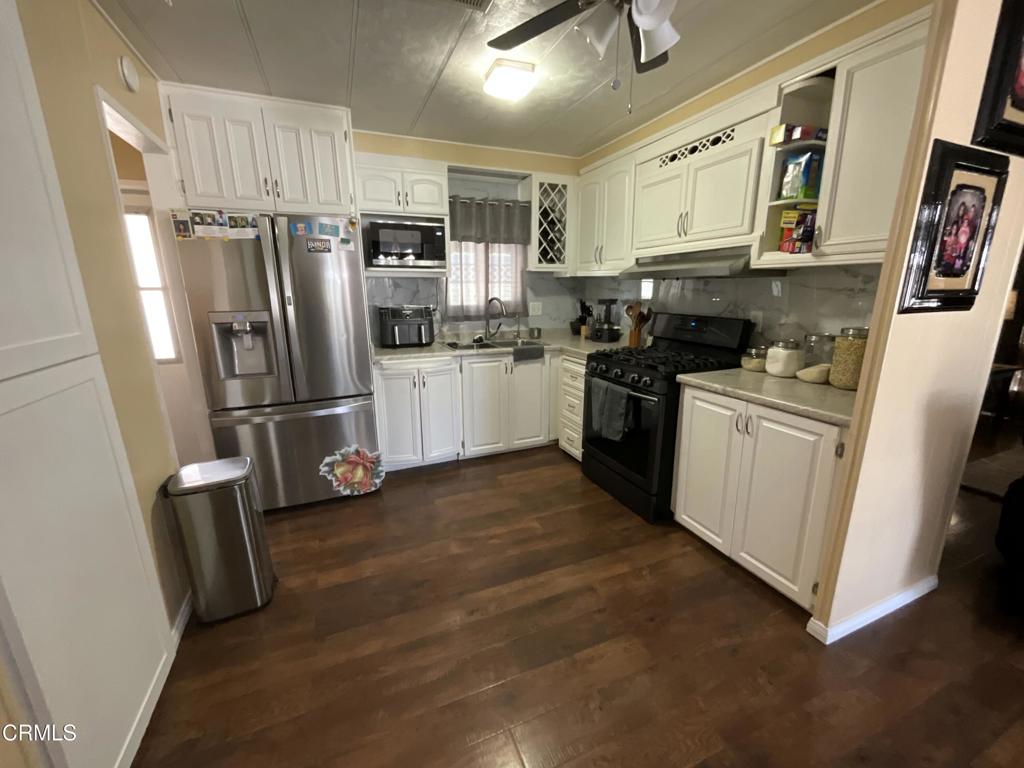 15433 West Telegraph Road, Unit 54 Santa Paula, CA 93060 - Photo 10 of 25 a kitchen with stainless steel appliances a refrigerator a sink and white cabinets