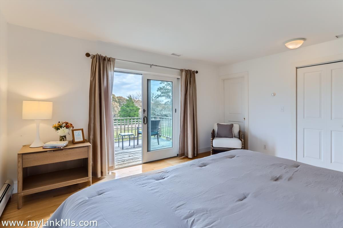 104 Pond View Farm Road West Tisbury, MA 02568 - Photo 24 of 55 a bedroom with a bed and a lamp next to a window