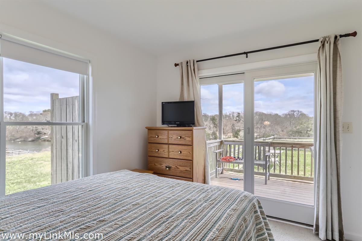 104 Pond View Farm Road West Tisbury, MA 02568 - Photo 47 of 55 a bedroom with a bed and a flat tv screen on dresser next to a window