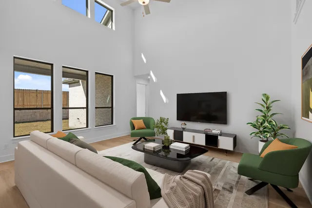 a living room with furniture flat screen tv and large windows