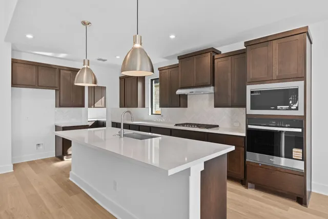 a kitchen with stainless steel appliances granite countertop a sink a stove and a refrigerator