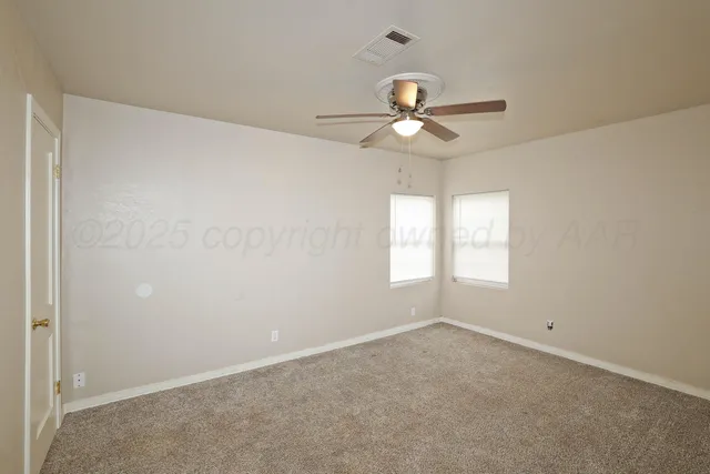 an empty room with a window and a fan