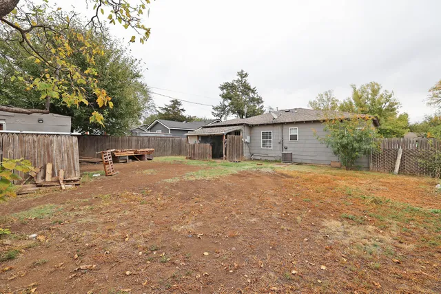 a view of a house with backyard and a tree