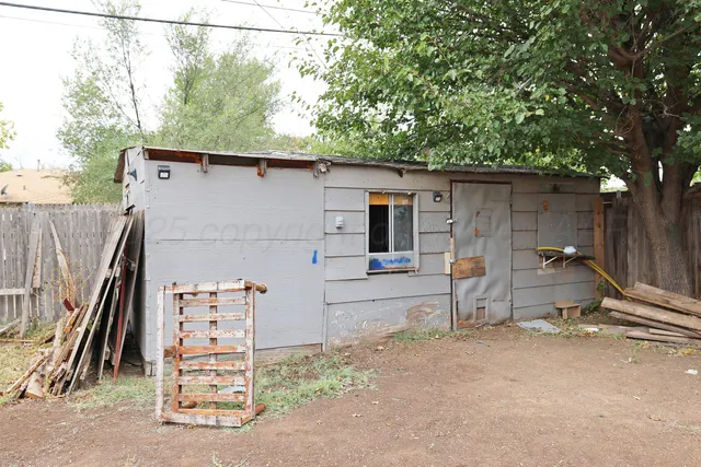 a backyard of a house with barbeque oven and glass table