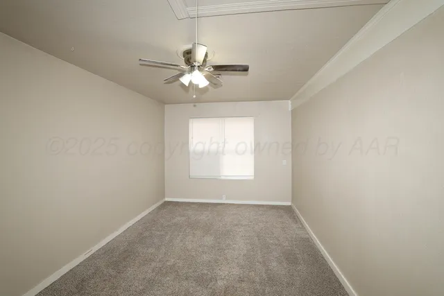 an empty room with a window and a fan