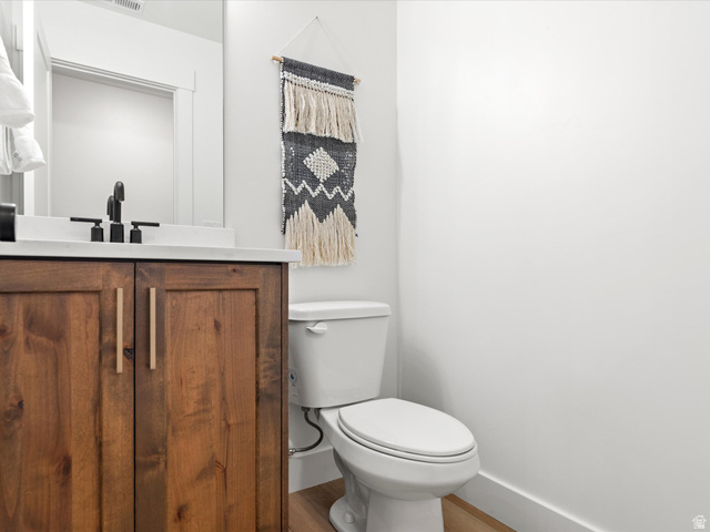 1267 West 2350 South Perry, UT 84302 - Photo 32 of 35 Wood-finish vanity with flat-panel doors, light-colored countertop, and matte black faucet