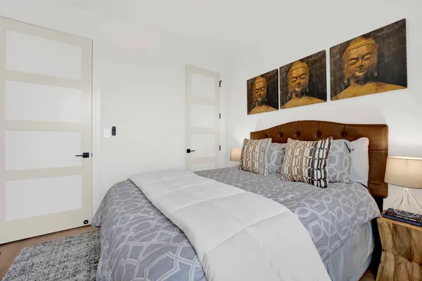 a bedroom with a bed and painting on the wall