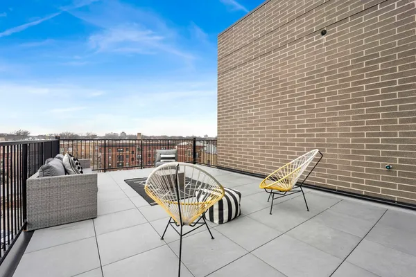 a roof deck with couches and wooden floor