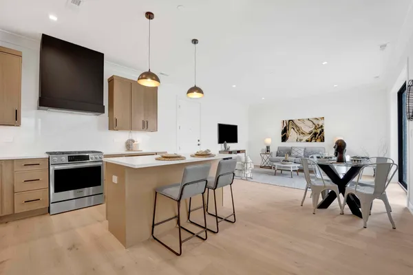 a living room with furniture a flat screen tv and kitchen view