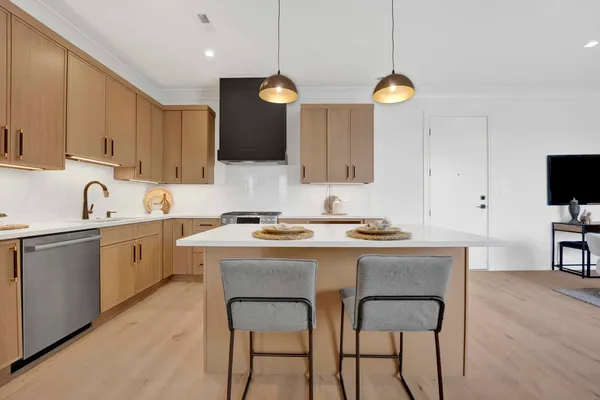 a kitchen with cabinets a sink stainless steel appliances and dining table