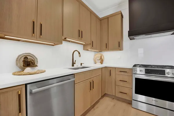 a kitchen with stainless steel appliances granite countertop a sink dishwasher a stove and a microwave oven with cabinets