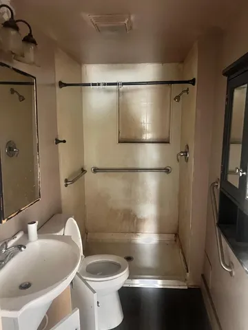 a bathroom with a sink a toilet and shower